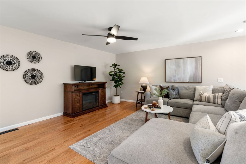 12 Silvermine Road Woburn, MA 01801 - Photo 14 of 36 a living room with furniture a fireplace and a flat screen tv