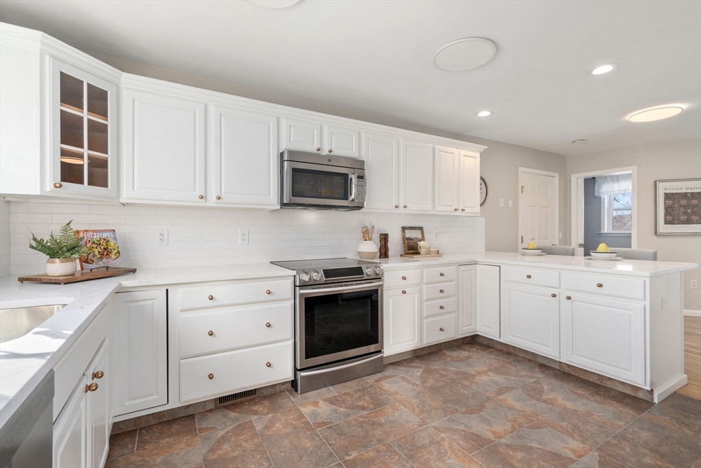 12 Silvermine Road Woburn, MA 01801 - Photo 9 of 36 a kitchen with white cabinets appliances and a sink