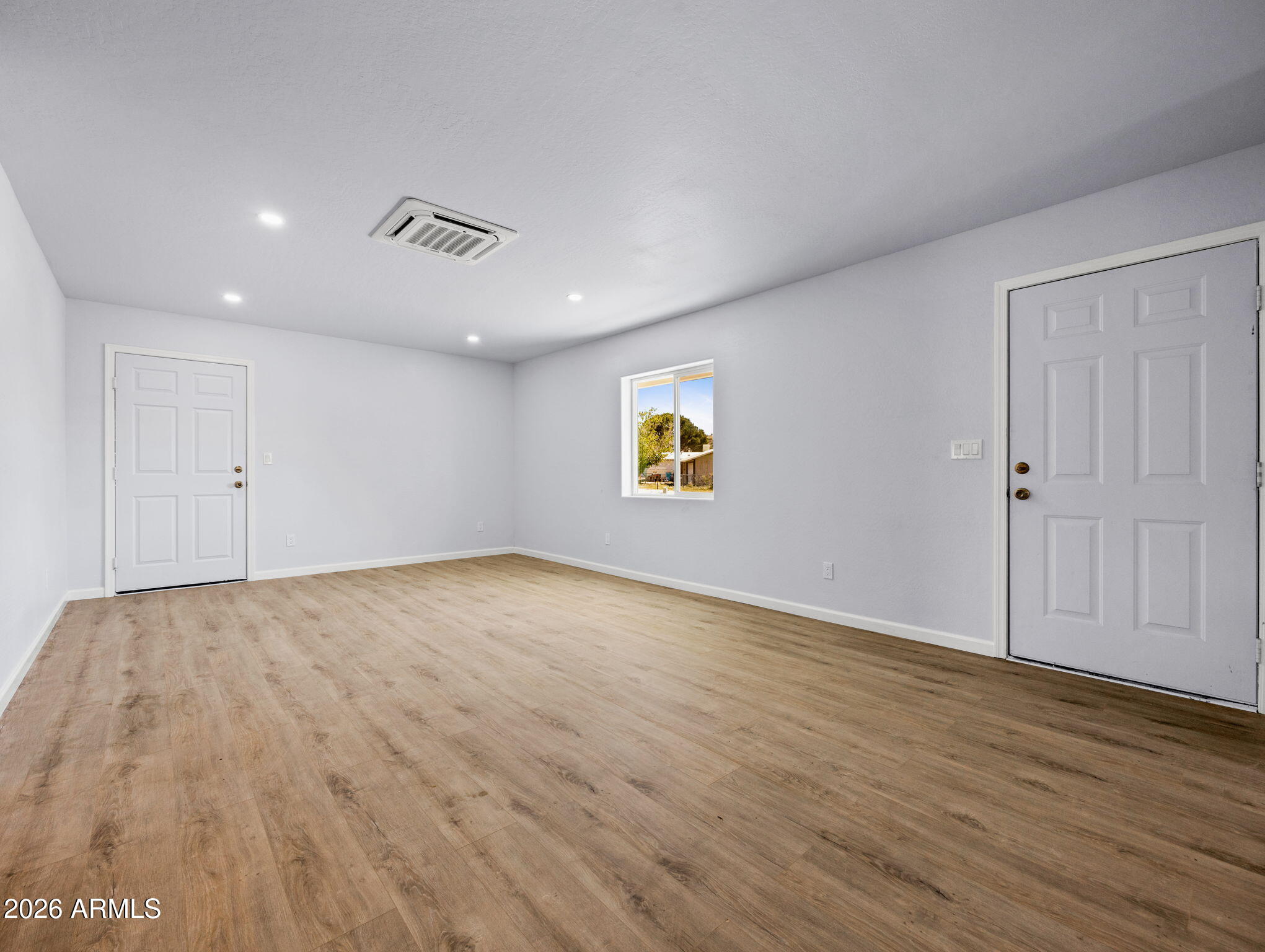18278 Frontier Road Peeples Valley, AZ 86332 - Photo 12 of 31 an empty room with wooden floor and windows
