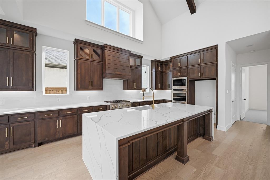 571 Twilight Drive Prosper, TX 75078 - Photo 2 of 30 a kitchen with stainless steel appliances granite countertop a sink stove and refrigerator