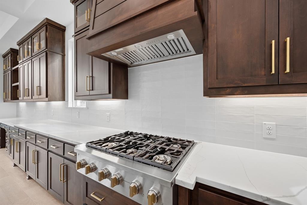 571 Twilight Drive Prosper, TX 75078 - Photo 5 of 30 a kitchen with cabinets and a stove top oven