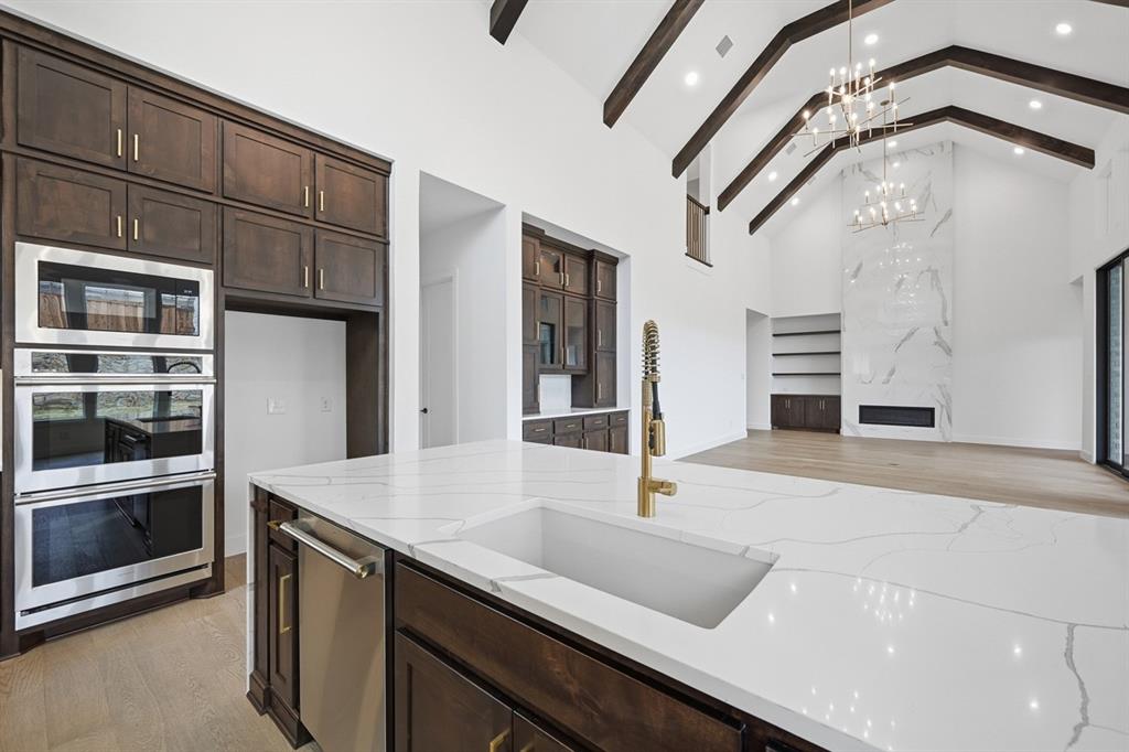 571 Twilight Drive Prosper, TX 75078 - Photo 6 of 30 a kitchen with a sink and stainless steel appliances