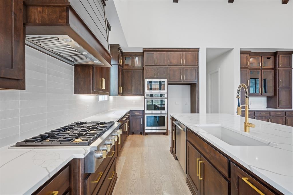 571 Twilight Drive Prosper, TX 75078 - Photo 7 of 30 a kitchen with stainless steel appliances a sink stove and cabinets