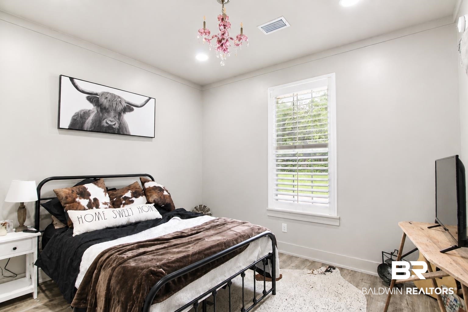 9825 Wolf Creek Ridge Elberta, AL 36530 - Photo 13 of 76 Bedroom featuring wood-finish flooring, a window with white louvered shutters, crown molding, a recessed ceiling light, and a decorative pink chandelier