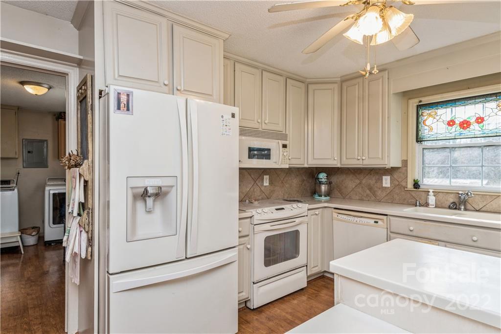 4600 Stallings Road Matthews, NC 28105 - Photo 13 of 38 a white kitchen with cabinets appliances and a wooden floor