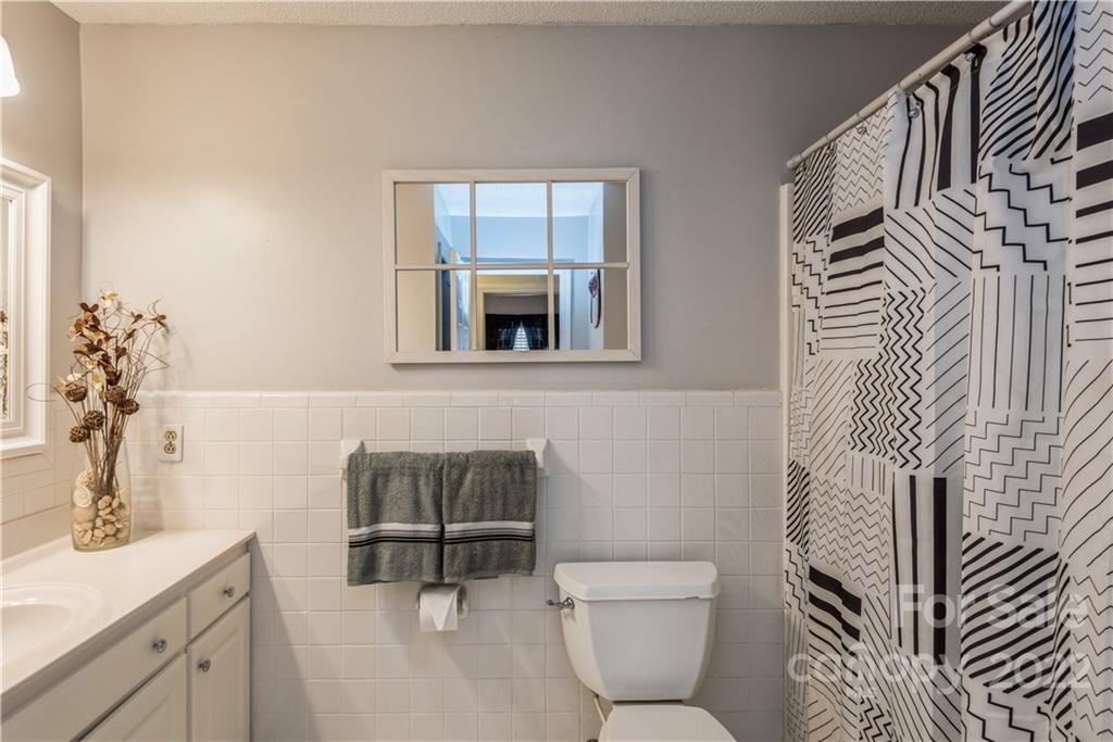 4600 Stallings Road Matthews, NC 28105 - Photo 22 of 38 a bathroom with a toilet a sink and mirror