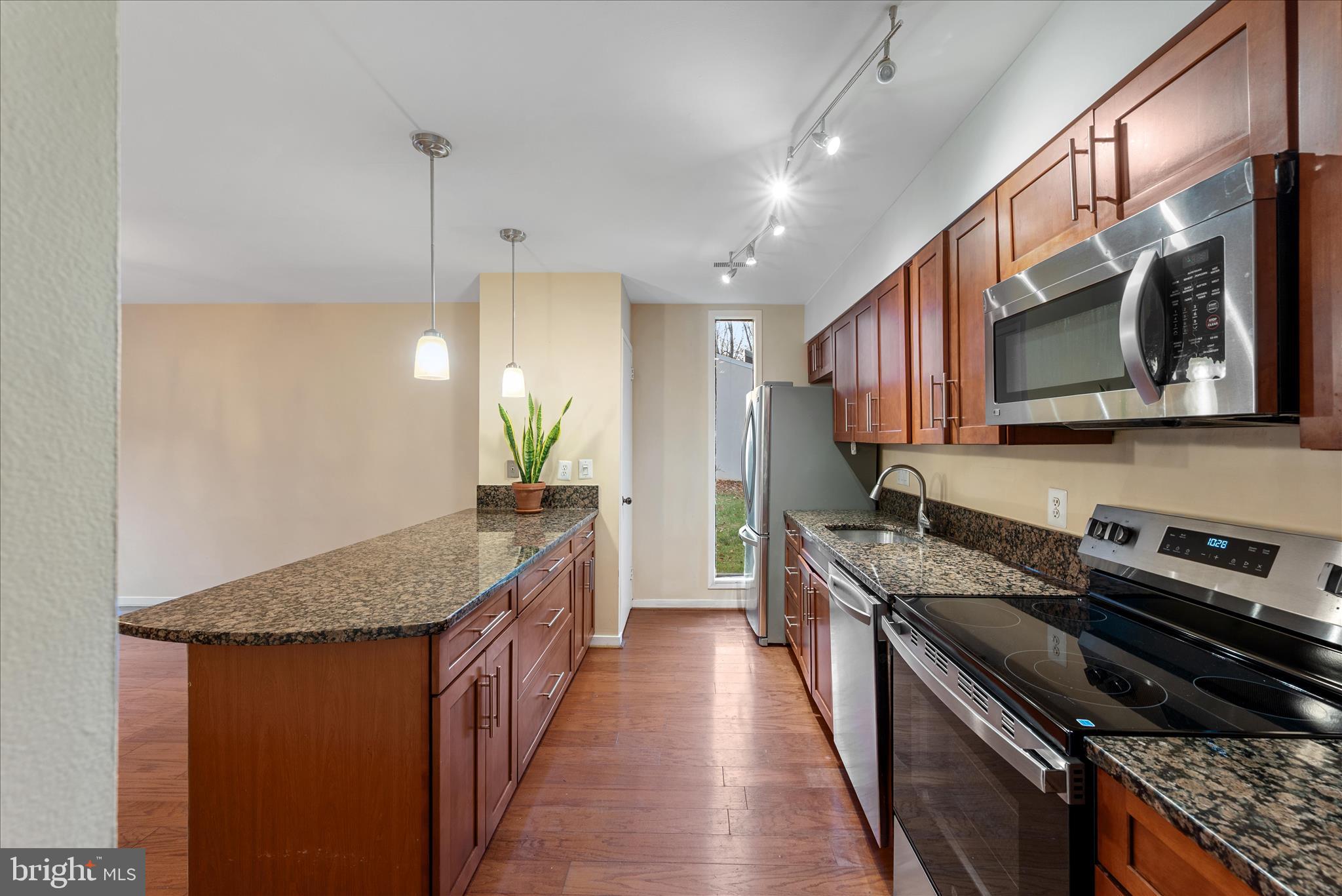 2337 Glade Bank Way Reston, VA 20191 - Photo 12 of 50 a kitchen with stainless steel appliances granite countertop a stove a sink and a microwave
