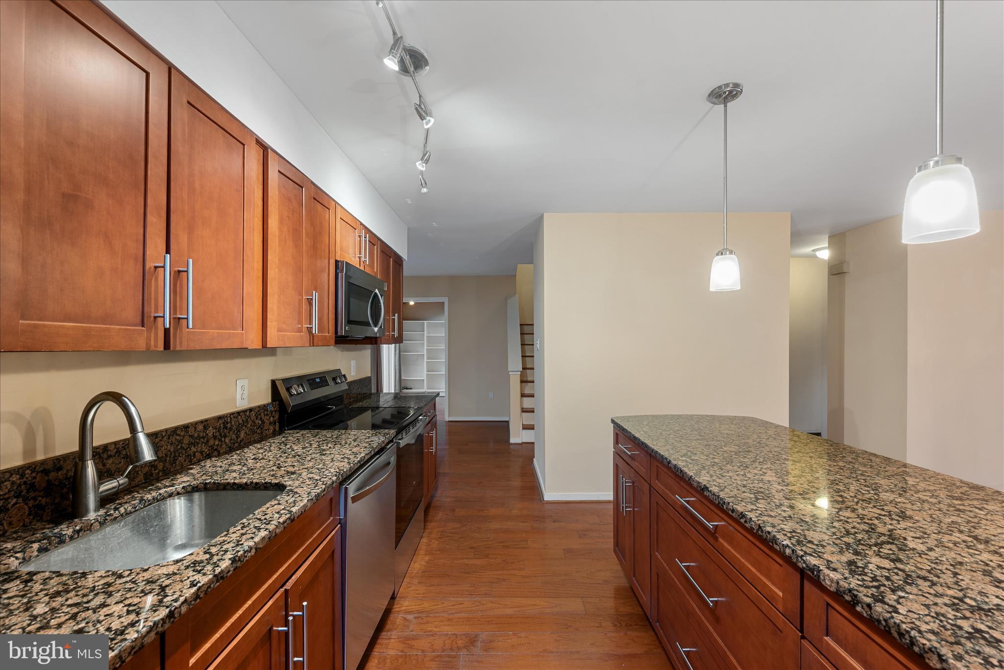 2337 Glade Bank Way Reston, VA 20191 - Photo 13 of 50 a kitchen with stainless steel appliances granite countertop a sink a stove and a wooden cabinets