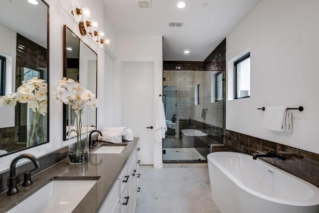 3601 Routh Street, Unit 2E Dallas, TX 75219 - Photo 9 of 14 Full bathroom with a sink, a freestanding tub, a stall shower, and visible vents
