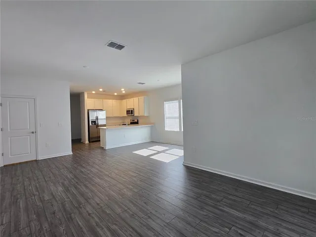 a view of a kitchen with wooden floor and a kitchen