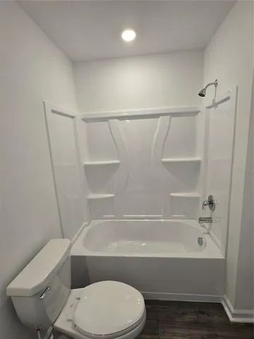 a bathroom with a granite countertop sink a toilet and a mirror