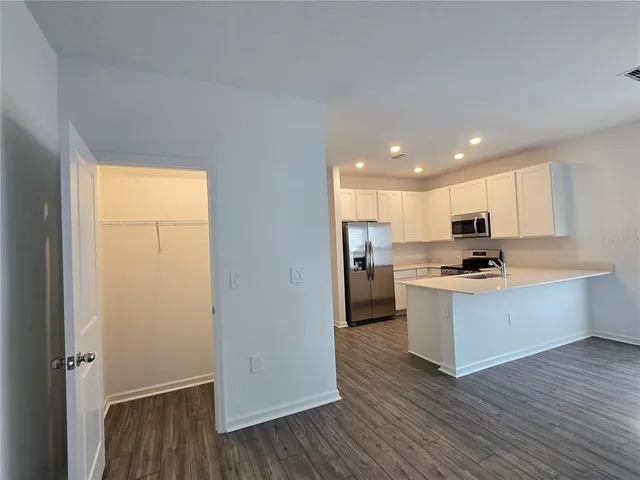 a kitchen with stainless steel appliances a refrigerator and wooden floor