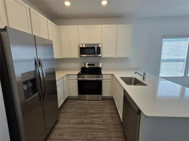 a kitchen with a sink a refrigerator and cabinets