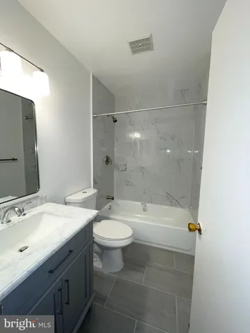 a view of an empty room with a chandelier fan