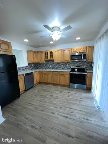 a large kitchen with granite countertop a large counter top stainless steel appliances and a lots of counter space