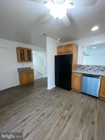 a kitchen with granite countertop wooden floors and white stainless steel appliances