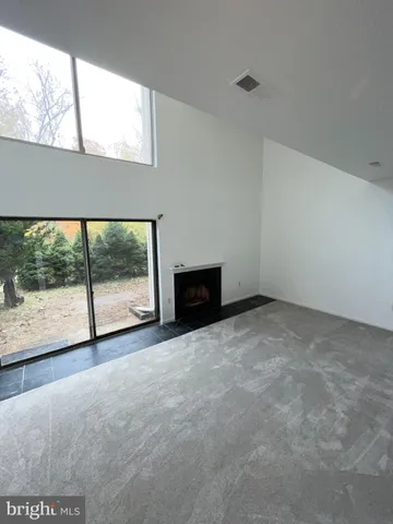 a view of an empty room with a fireplace and a window