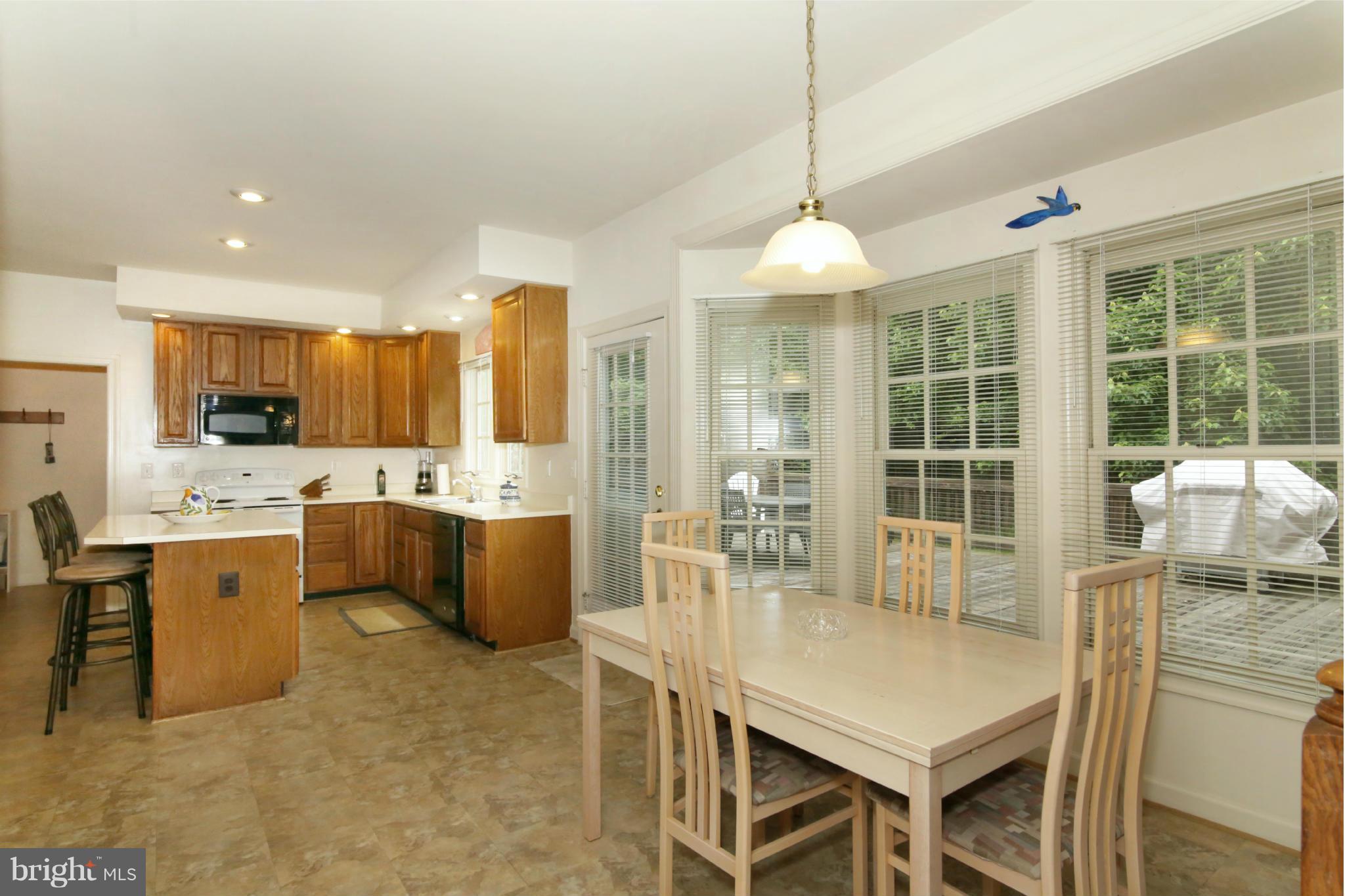 5483 Ashleigh Road Fairfax, VA 22030 - Photo 8 of 30 a kitchen with a table chairs microwave and refrigerator