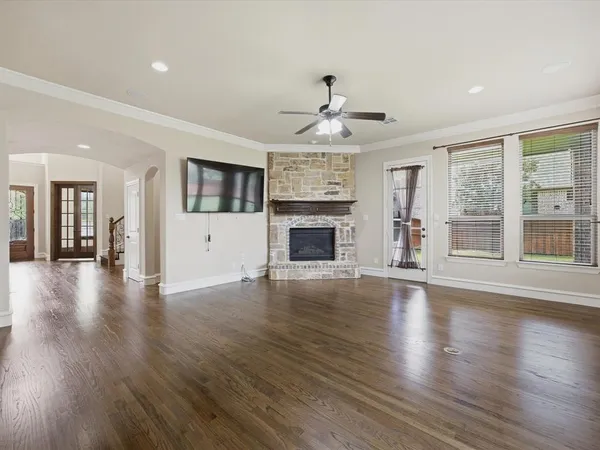 an empty room with wooden floor and fireplace