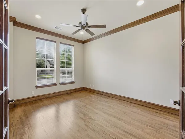 a view of an empty room with a window and wooden floor