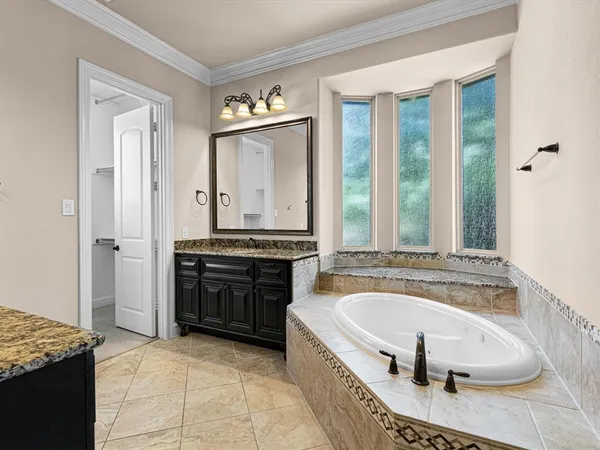 a spacious bathroom with a tub sink and mirror