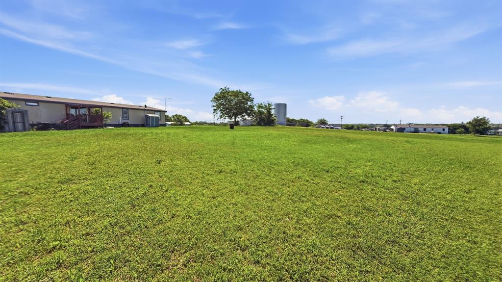 185 Private Road 4437 Rhome, TX 76078 - Photo 27 of 28 Expansive grassy lawn with a single mature tree