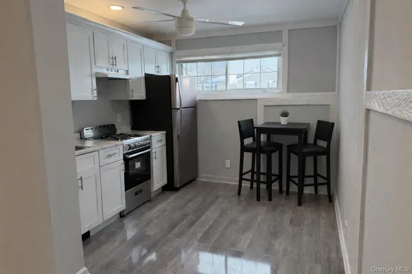 a kitchen with a stove a sink and chairs