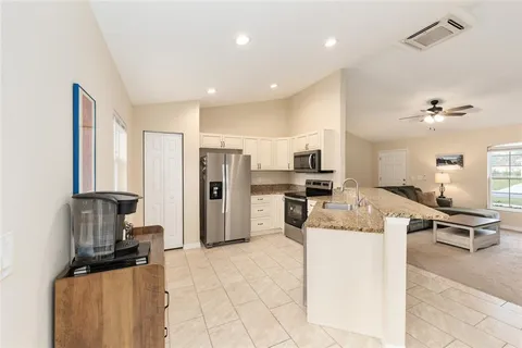 a kitchen with stainless steel appliances kitchen island granite countertop a refrigerator and a stove top oven