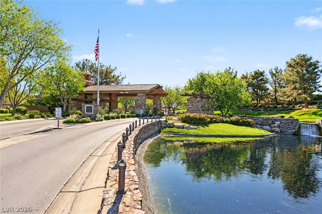 6 Mohansic Road Henderson, NV 89052 - Photo 32 of 38 A stone-paved entry road leads past a tranquil pond to the gated neighborhood entrance.