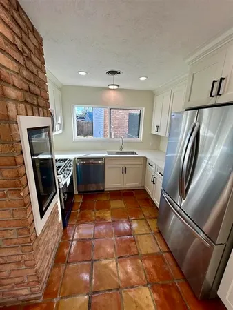 a kitchen with stainless steel appliances granite countertop a refrigerator and a stove