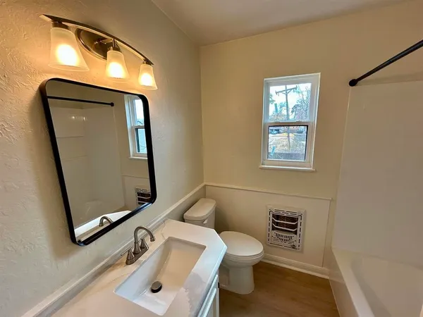 a bathroom with a toilet sink and mirror