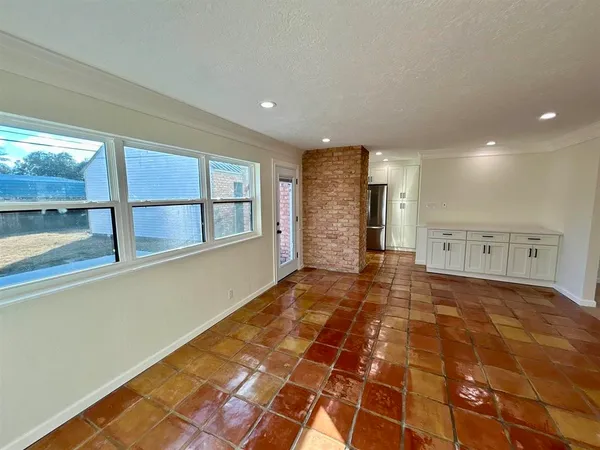 a view of empty room with wooden floor and windows