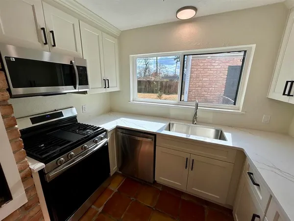 a kitchen with a sink stove and microwave