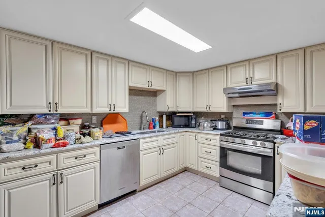 a kitchen with granite countertop a sink stainless steel appliances and cabinets