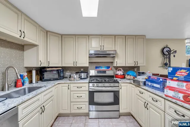 a kitchen with stainless steel appliances granite countertop a sink a stove and cabinets