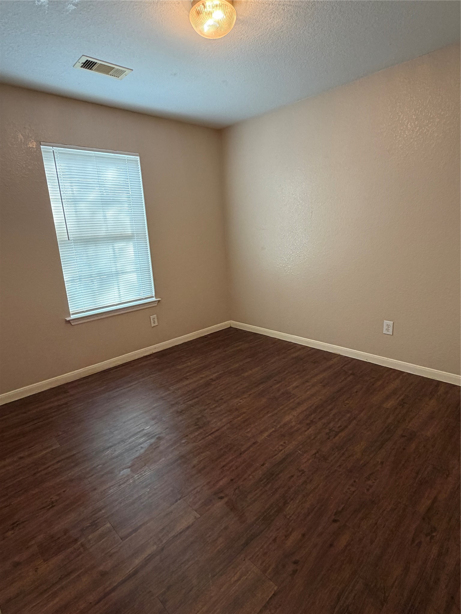 13230 Montclair Point Court Houston, TX 77047 - Photo 4 of 16 a view of an empty room with wooden floor and a window