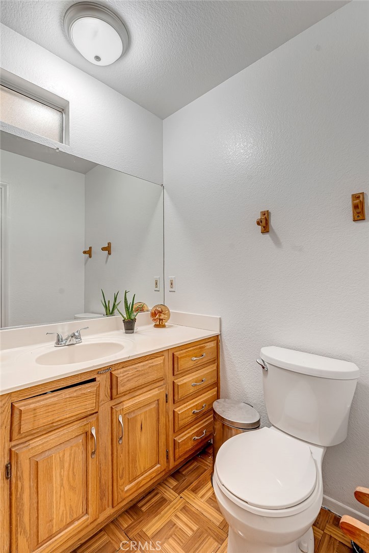 318 Old Toll Road Lake Arrowhead, CA 92352 - Photo 17 of 44 a bathroom with a granite countertop toilet sink and mirror