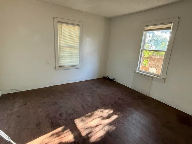 a view of a livingroom with wooden floor and a window