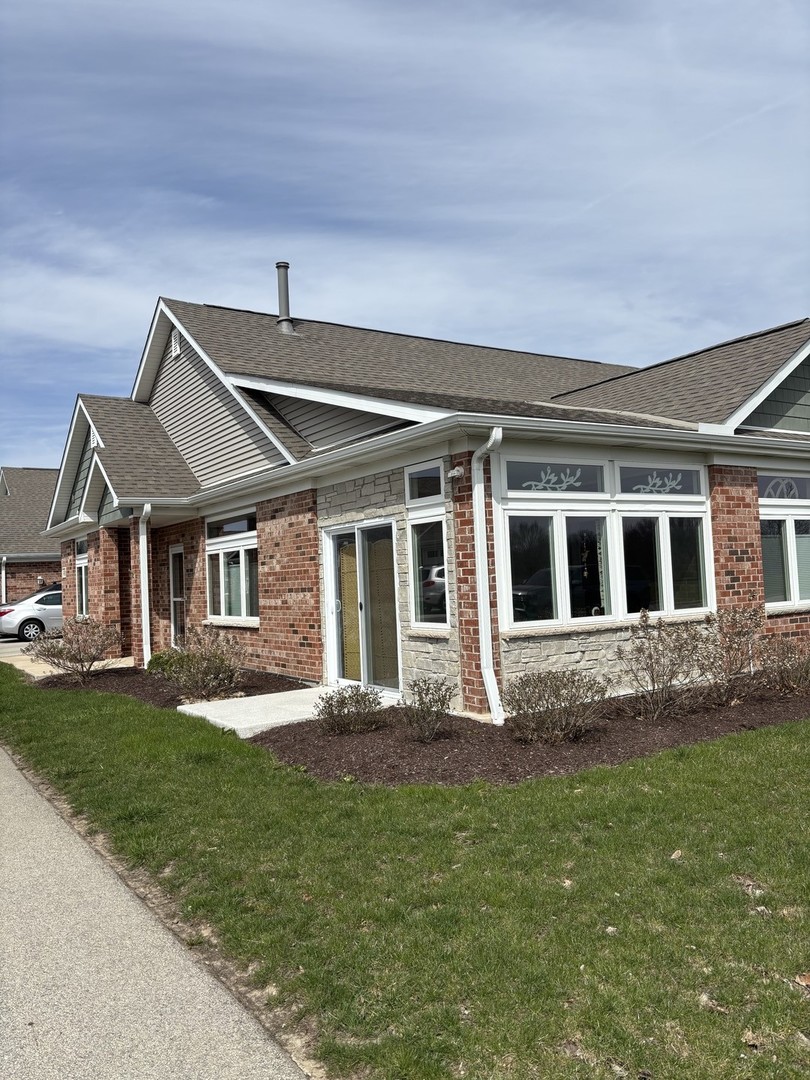 408 Stearn Drive, Unit 408 Genoa, IL 60135 - Photo 2 of 34 a front view of a house with a yard