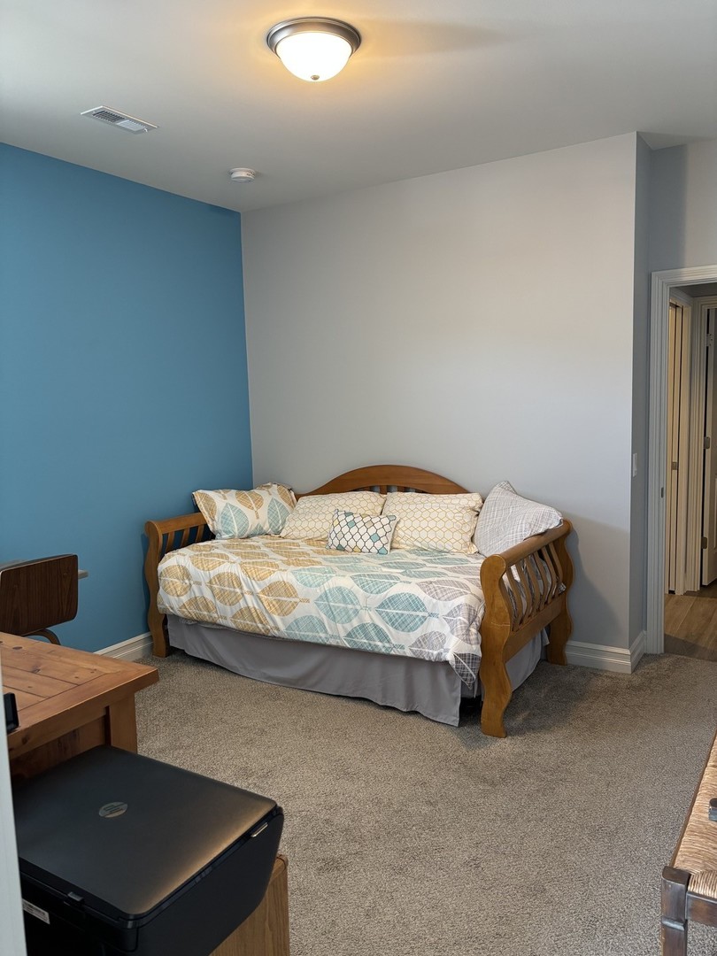 408 Stearn Drive, Unit 408 Genoa, IL 60135 - Photo 21 of 34 a bedroom with a bed a table and chair