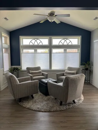 a living room with furniture wooden floor and a large window