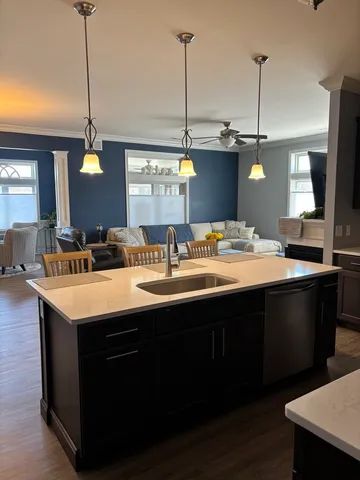 a kitchen with a sink and a wooden floor