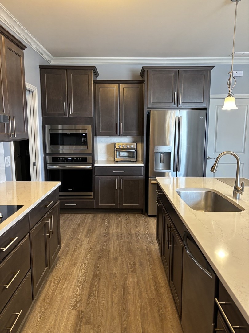 408 Stearn Drive, Unit 408 Genoa, IL 60135 - Photo 9 of 34 a kitchen with wooden cabinets and stainless steel appliances