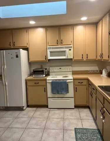 a kitchen with a stove sink and a refrigerator