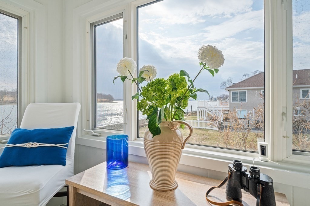 121 Edgewater Road Hull, MA 02045 - Photo 15 of 42 a vase of flowers sitting on a table with a glass window
