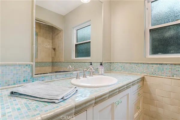 a bathroom with a granite countertop sink and a mirror