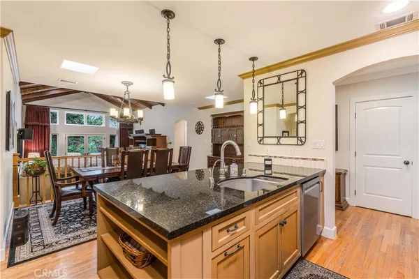 a kitchen with stainless steel appliances granite countertop a sink a stove and a wooden floors