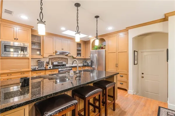 a kitchen with stainless steel appliances granite countertop a stove a sink and a refrigerator