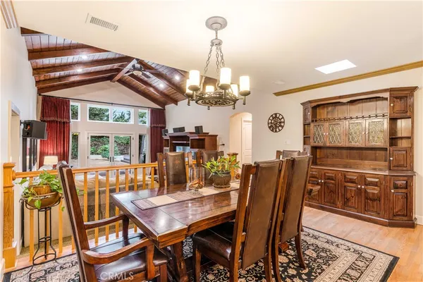 a view of a dining room with furniture a chandelier and wooden floor