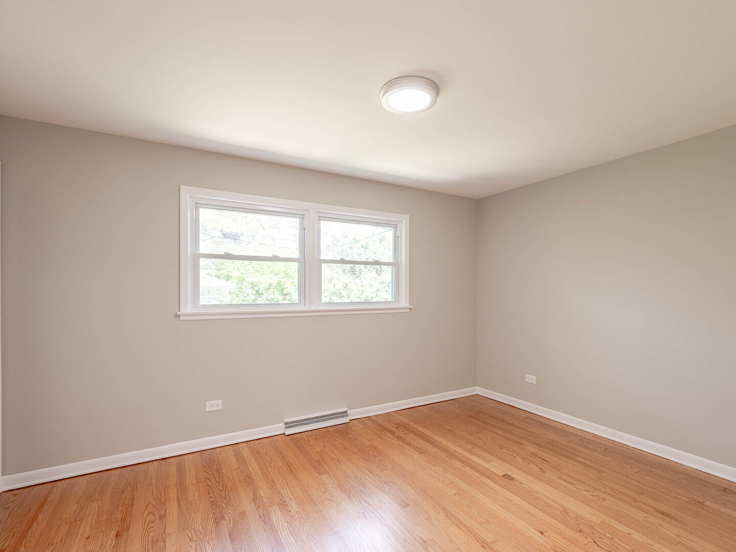 2304 Oakton Street Park Ridge, IL 60068 - Photo 8 of 14 an empty room with wooden floor and windows